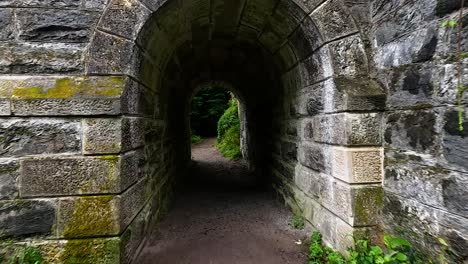 walking through a stone tunnel into nature