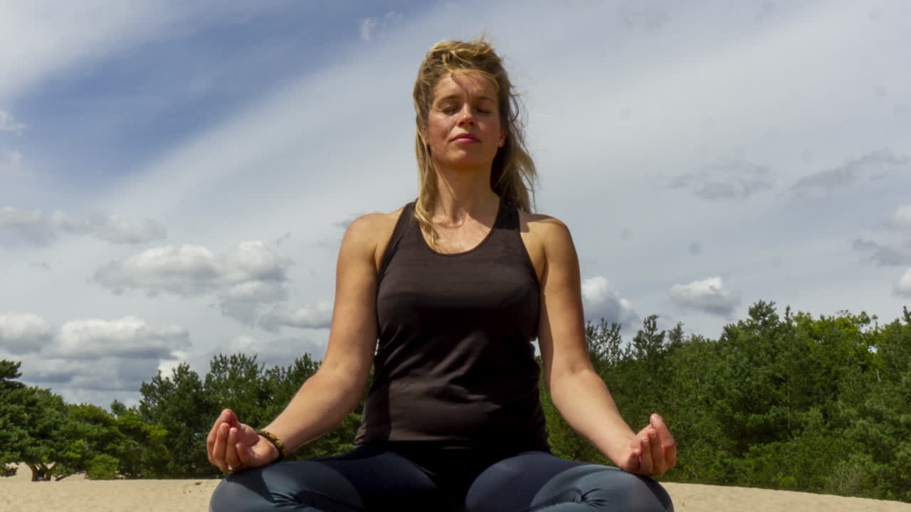 lapso de tiempo de la mujer meditando en las dunas de arena - alejar