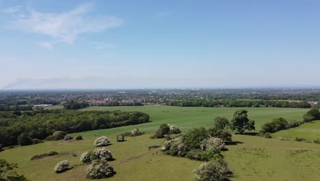 Clip-Aéreo-De-Drones-Avanzando-Sobre-El-Campo-Con-La-Ciudad-De-Manchester-En-El-Reino-Unido-Y-El-Incendio-Del-Valle-De-Sankey-En-El-Fondo