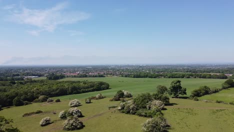aerial drone clip moving forward over the countryside with the city of manchester in uk and sankey valley fire in the background