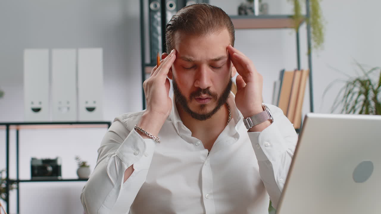 Tired lebanese business man suffering from headache problem tension migraine stress at home office