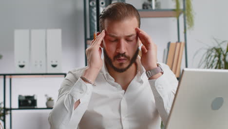 tired lebanese business man suffering from headache problem tension migraine stress at home office