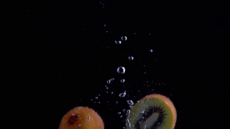 Kiwi-Cayendo-Al-Agua-En-Cámara-Superlenta,-Fondo-Negro,-Muchas-Burbujas-De-Aire,-4k240fps