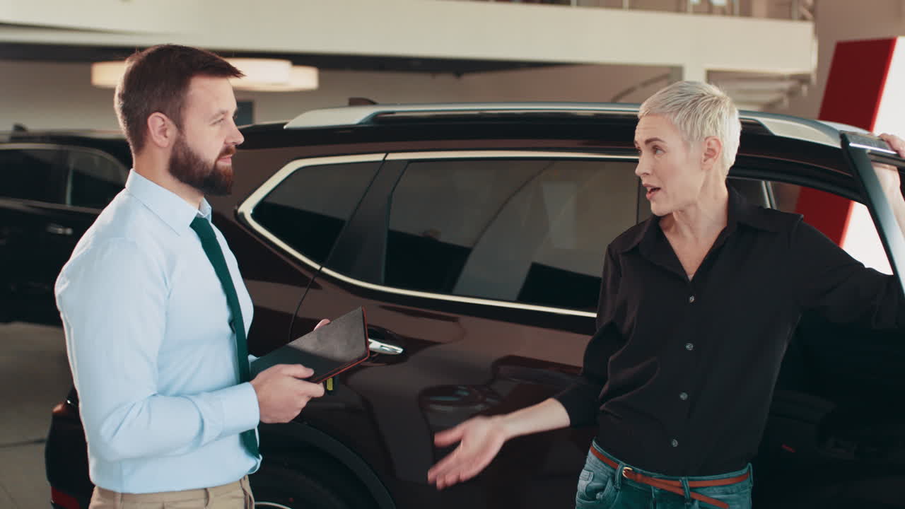 vendedor de automóviles discutiendo con un cliente en la sala de exposiciones