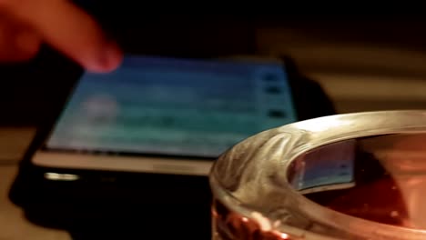 candles lit on table, girl swiping and browsing on smart phone blurred, cinematic slider slowly moving right