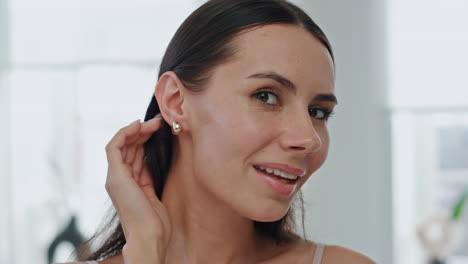 modelo feliz poniendo pendientes en casa pov video. mujer satisfecha enderezando el cabello