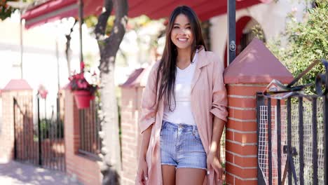 young woman in a pink coat on the street