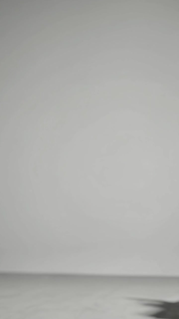 Minimalist video concept with a wide-angle shot of a shadow on a plain, light gray background