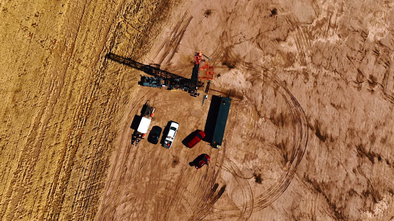 Circling high above the little site for drilling oil. A few trucks with the equipment for resources production.