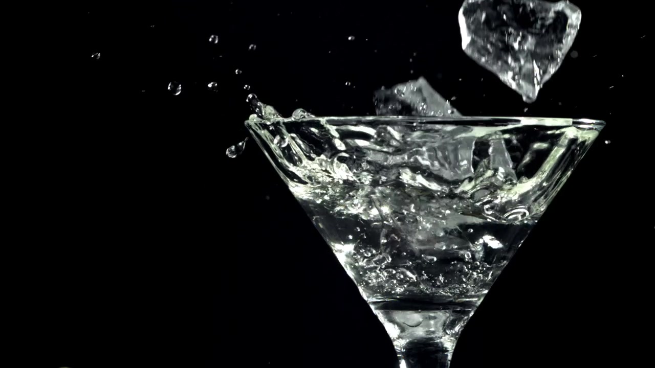 Cubetti di ghiaccio che schizzano in un bicchiere da Martini al rallentatore