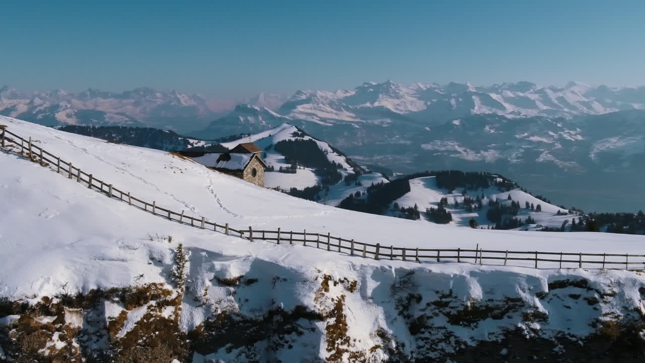 A drone movie along a mountain cliff with a stuning scenic view.
A fantastic movie on a winterday in the mountains.
There is also a little house visible on the top of the mountain.