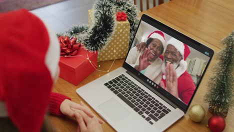 Mujer-Caucásica-Feliz-En-Videollamada-Con-Una-Pareja-Mayor-En-Navidad