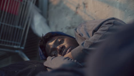 homeless black man lying on street and shivering from cold