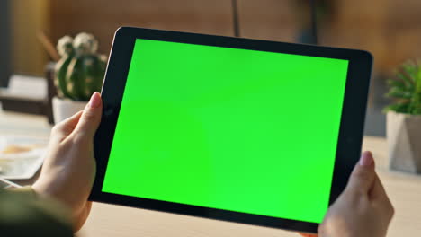tableta de pantalla verde de primer plano en manos de una mujer de negocios. mujer sosteniendo un dispositivo de maqueta.