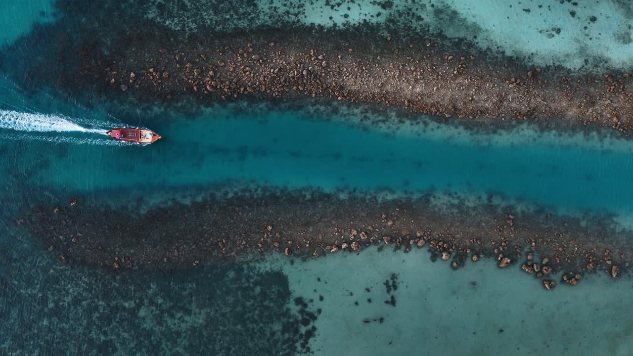 Red boat going into a canal