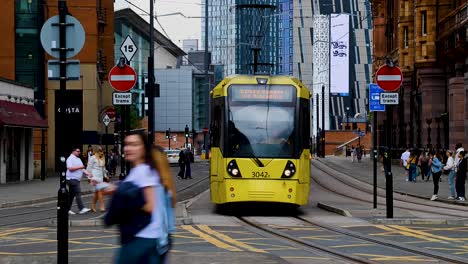 manchester metrolink within central manchester time lapse with people walking through, manchester