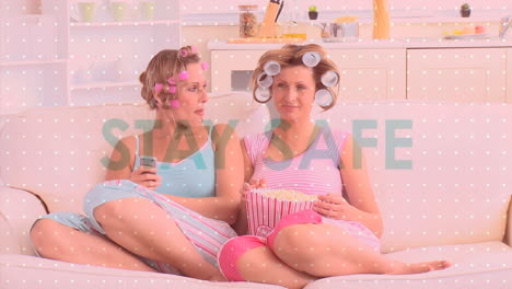 animación del mensaje de distanciamiento social sobre dos mujeres caucásicas comiendo palomitas de maíz