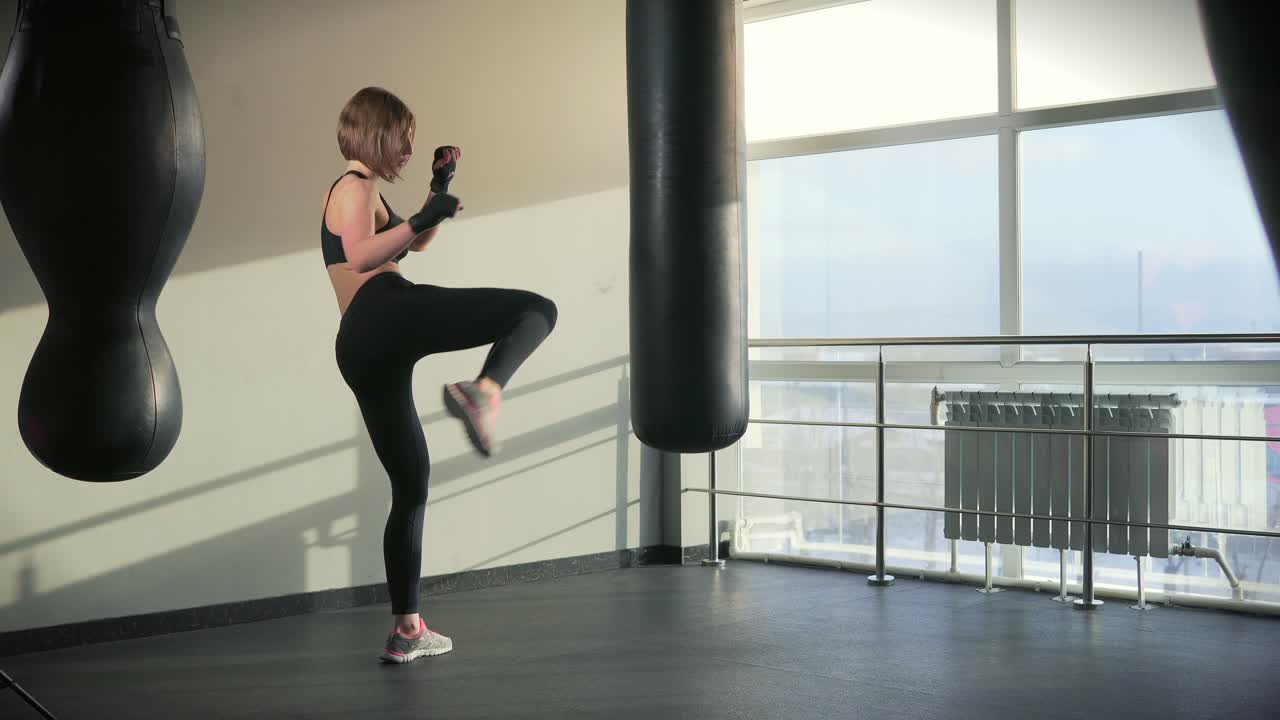Woman practicing kickboxing in a gym