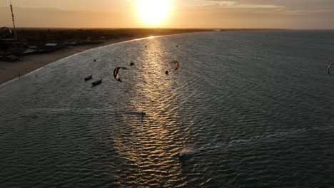 tracking drone shot of kiteboarder on the atlantic ocean at sunset with golden hour colors in cajueiro da praia, piaui, brazil