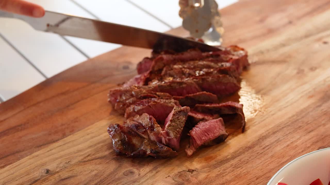 Slicing beef steak with fresh vegetables in a well-lit kitchen setting. Close-up shots emphasize texture and vibrant colors