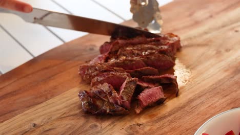 slicing beef steak with fresh vegetables in a well-lit kitchen setting. close-up shots emphasize texture and vibrant colors