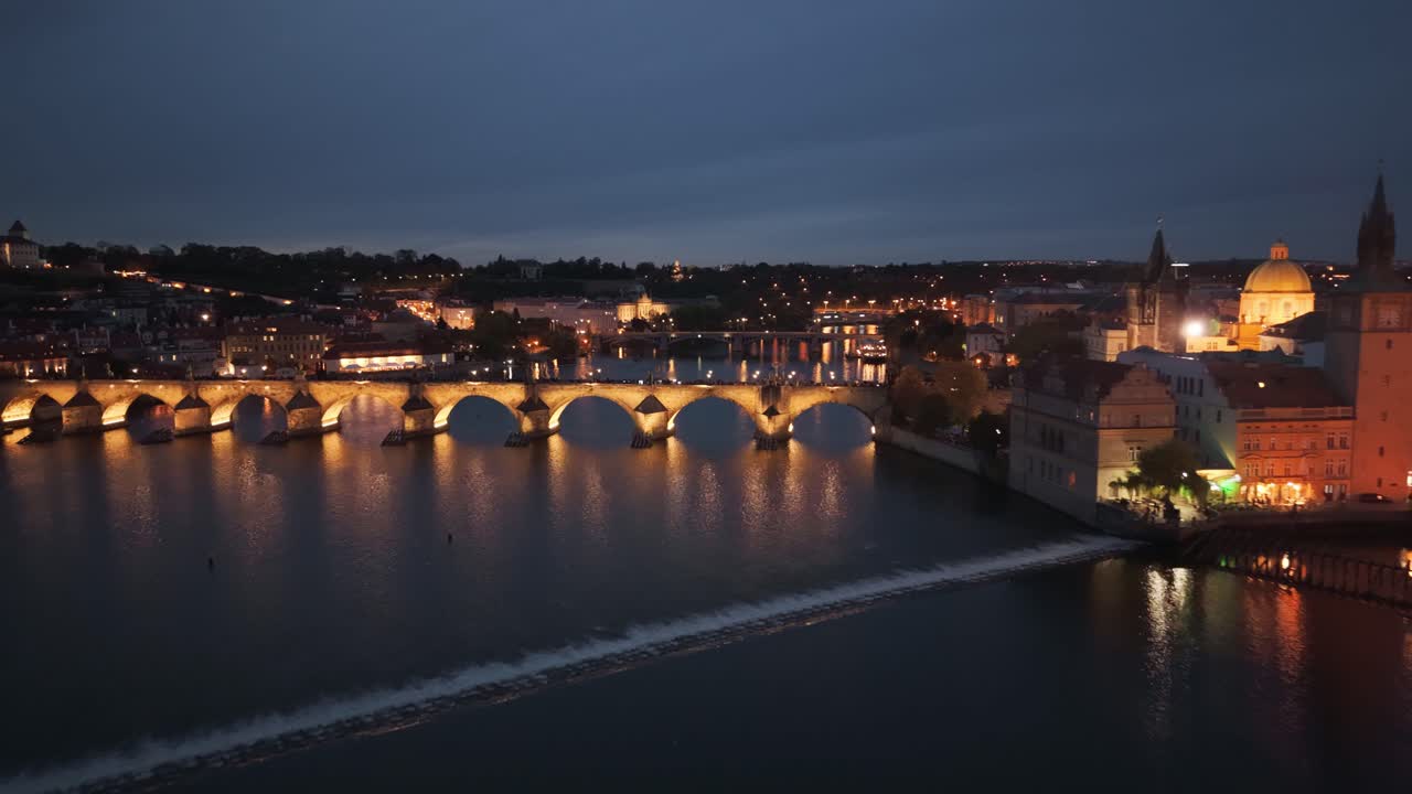 Aerial night view of Charles Bridge and Prague Castle over Vltava River, Czech Republic