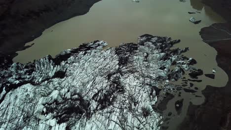 vista superior aérea sobre el glaciar sólheimajökull, derritiéndose en el agua, en verano, islandia