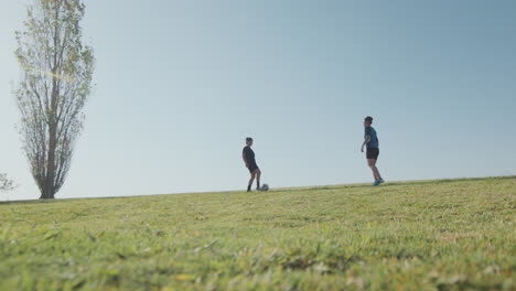 wide shot of two female soccer players training on green field