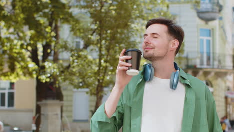 happy man enjoying morning coffee hot drink and smiling relaxing, taking a break on city street