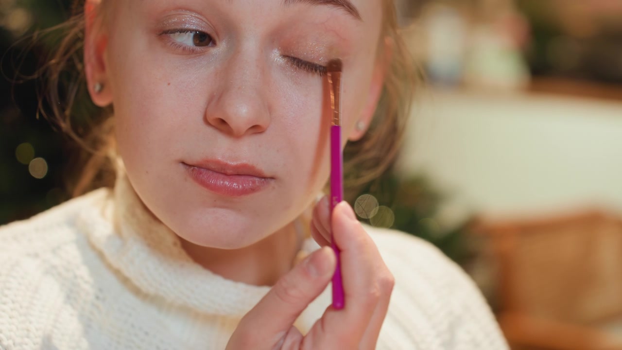 Young Woman Applying Shimmer Eyeshadow with a Brush