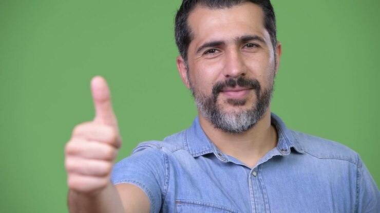 Affascinante uomo persiano barbuto che fa il gesto del pollice in su