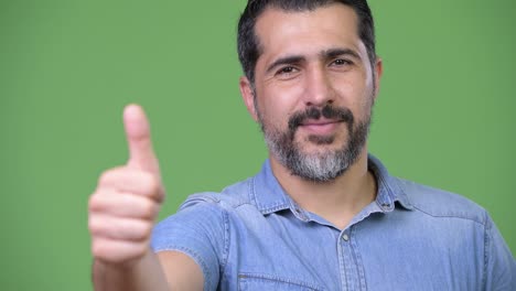 handsome persian bearded man giving thumbs up