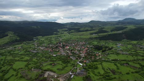 mountain village of voskopoja surrounded by lush greenery and dense black pine forests, nestled in a serene landscape