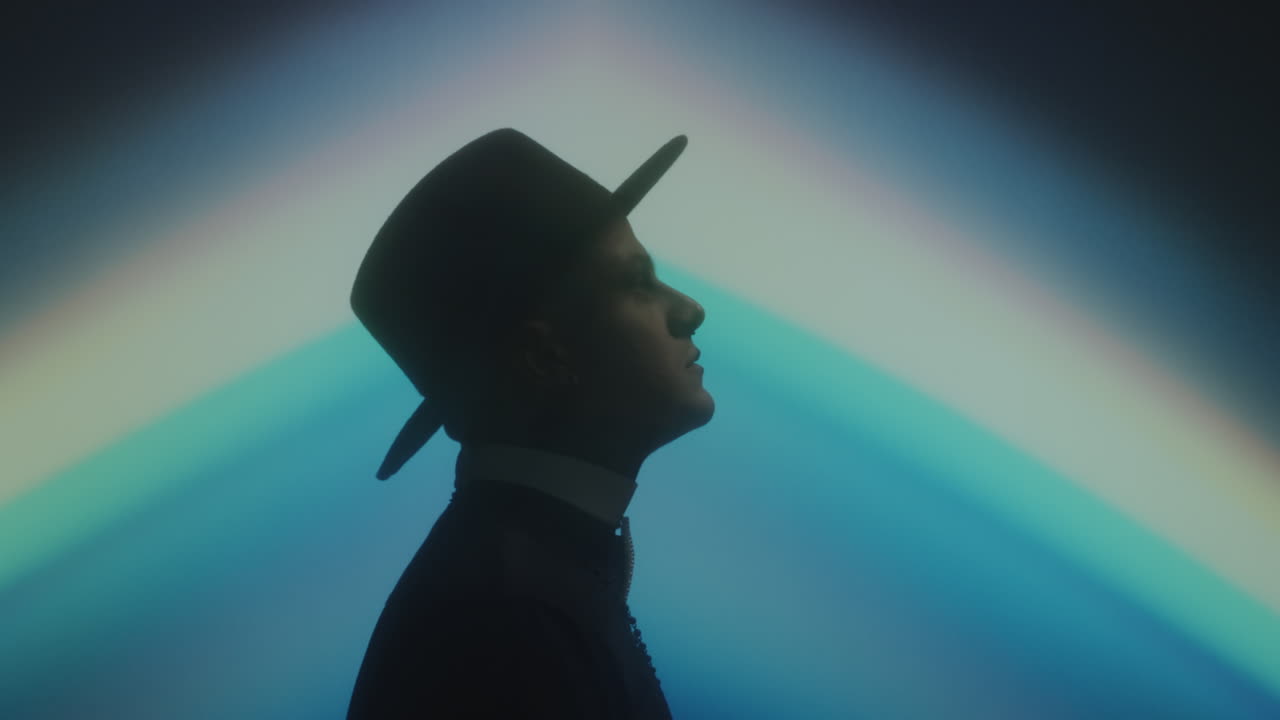 Priest in Dark Studio with Rainbow Projection