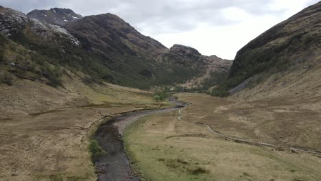 Aerial-perspective-that-showcases-the-interplay-between-the-rugged-mountains-and-the-gentle-valley-at-Ben-Nevis,-Scotland