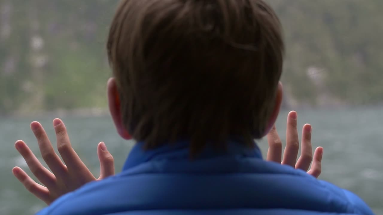 Young Boy Looking Out of Ship Window