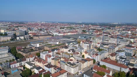 Magic-aerial-top-view-flight-Munich-main-station-in-city-center,-German-Bavarian-Town-at-sunny-clear-sky-day-2023