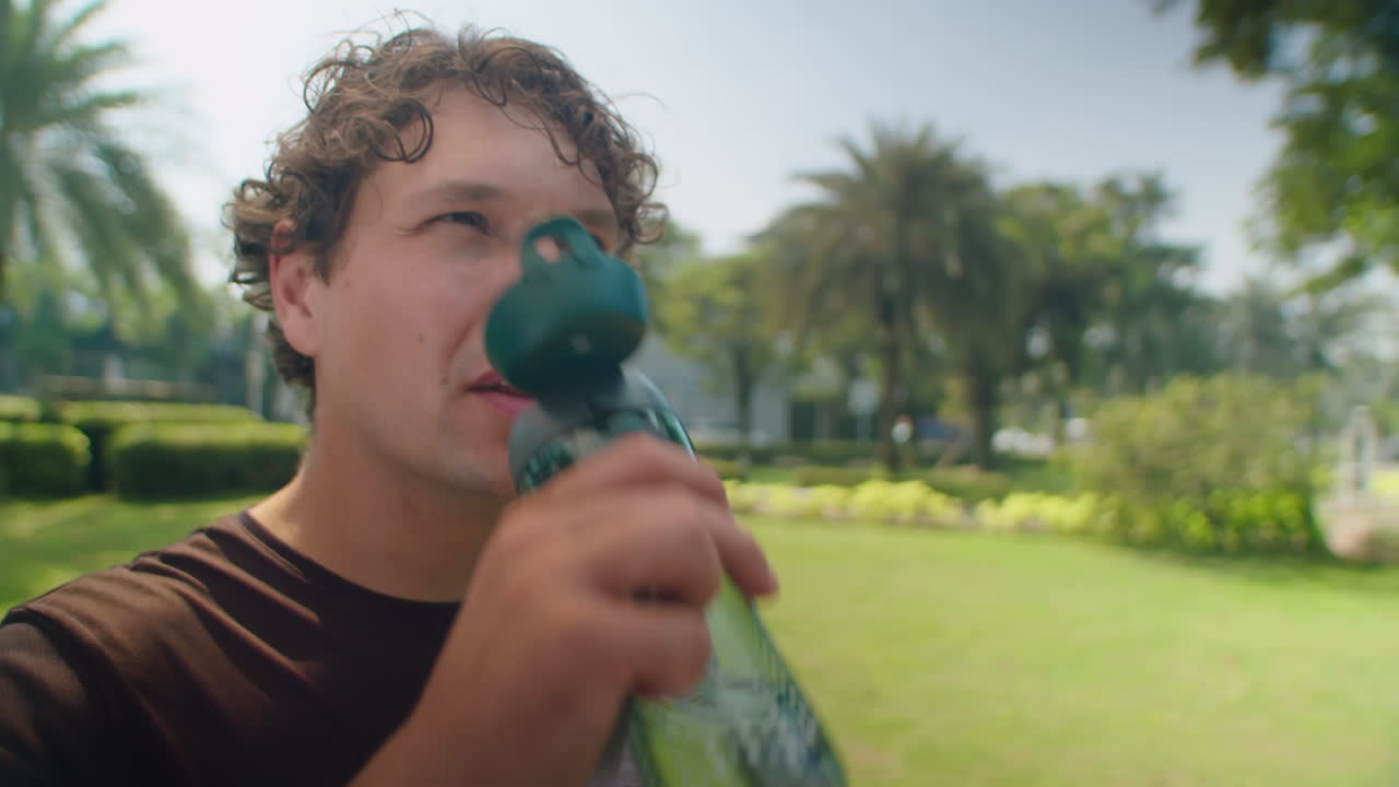 Man Drinking Water after Training in Park