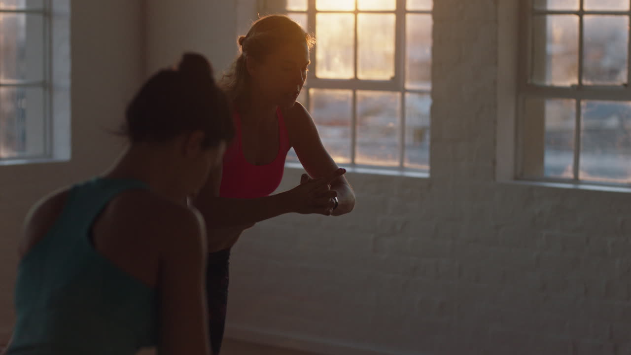 beautiful yoga class instructor teaching young group practicing warrior pose enjoying healthy lifestyle exercising in studio at sunrise