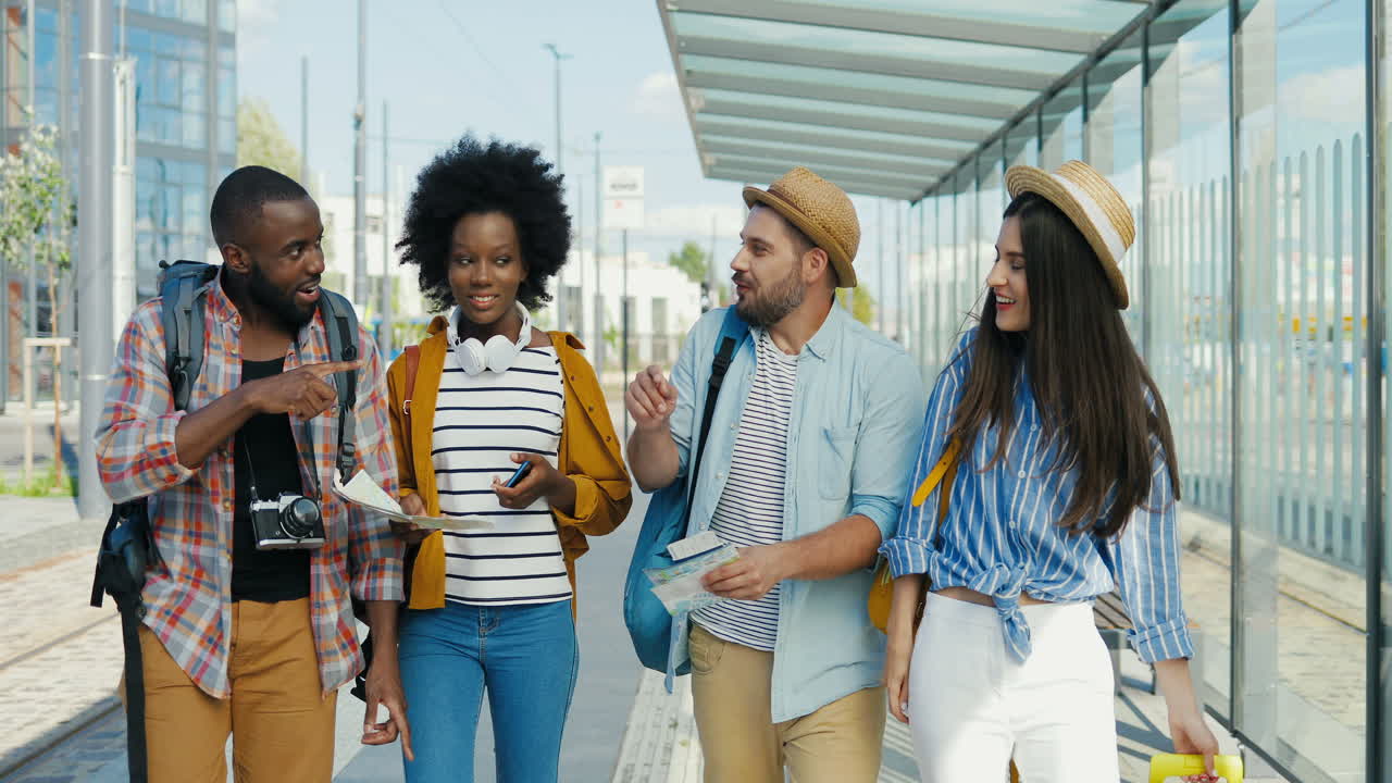grupo multiétnico de amigos viajeros caminando, riendo y hablando en la estación de tren