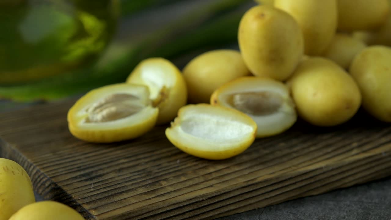 las palmeras de dátiles frescas se colocan en la mesa con aceite, concepto de alimentos saludables. palmeras de dátils. frutas crudas de palmieras de dátiles (phoenix dactylifera)