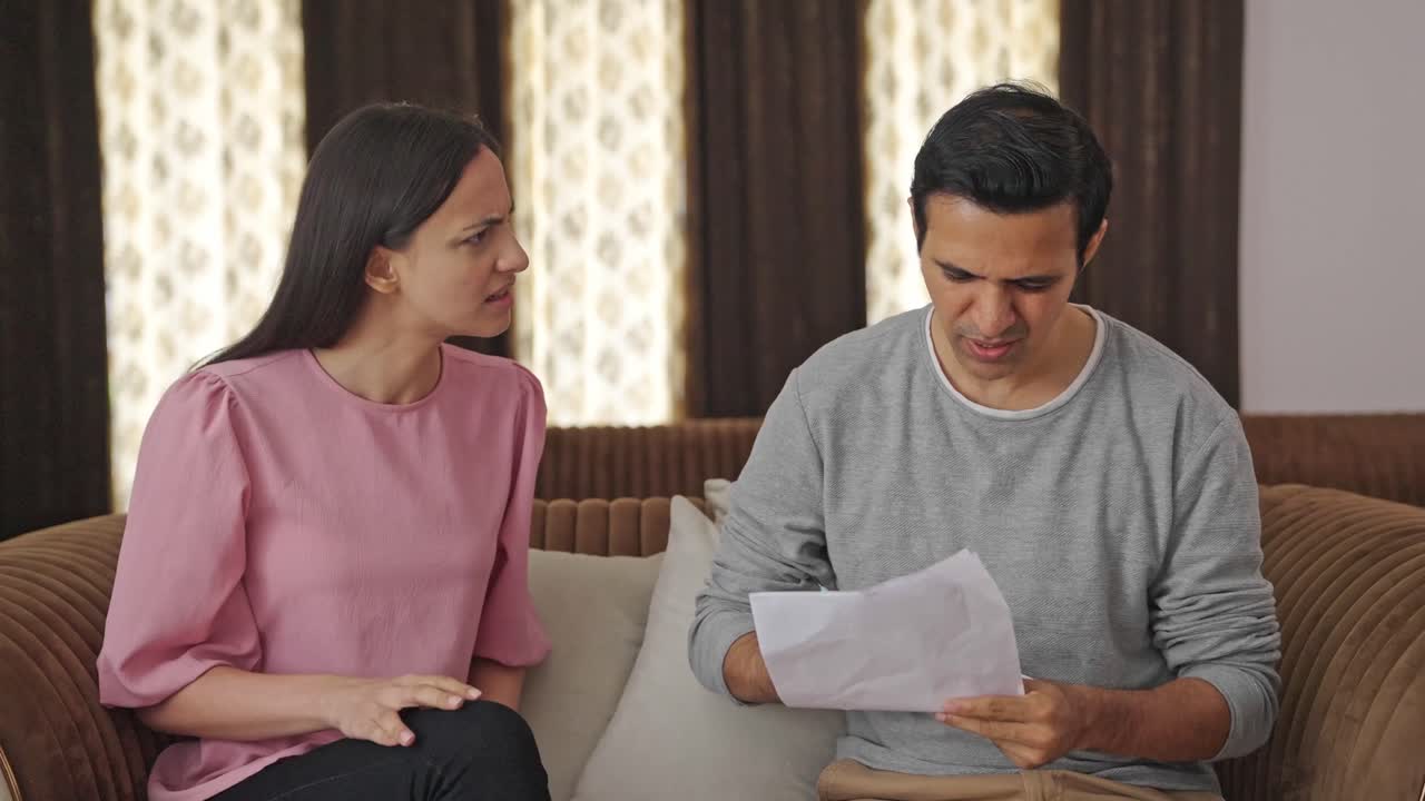una pareja india enojada firmando un documento de divorcio