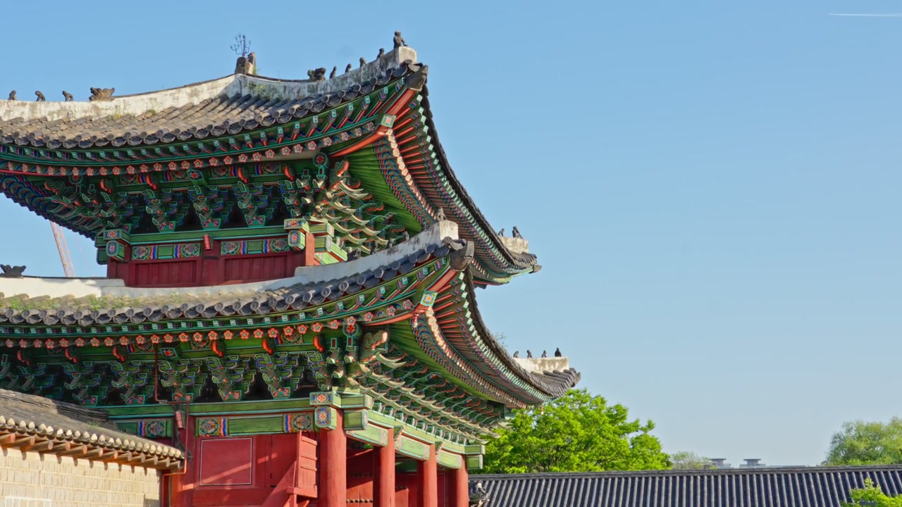 Il Palazzo Changdeokgung è un sito Patrimonio dell'Umanità UNESCO che presenta elaborate pitture Dancheong, tetti in tegole curve e figurine Japsang lungo le grondaie della Porta Donhwamun sotto un cielo luminoso.