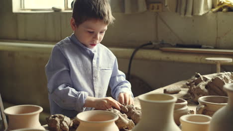 young boy shaping clay