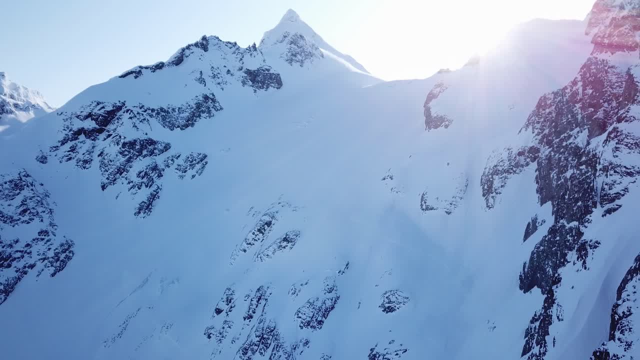 얼어붙은 산들 뒤로 태양이 정점을 찍고 있다