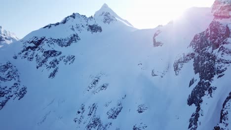 Sun-peaking-behind-frozen-mountains