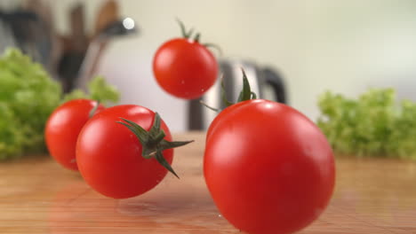 cherry tomatoes falling onto the wet wooden cutting board, bouncing and splashing water droplets in macro and slow motion