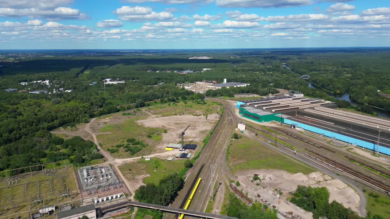 Hennigsdorf substation, distributing electricity and surrounded by a lush green forest in Brandenburg, Germany. Perfect aerial view flight panorama overview drone
