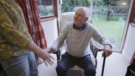 elderly man receiving assistance from a woman