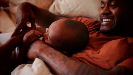 happy loving father playing with little son in bed